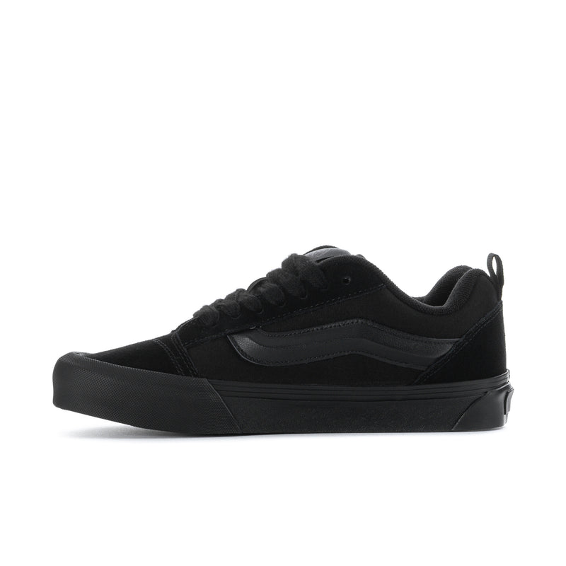 Men's black low-top lace-up skate shoe with textured toe and side panel