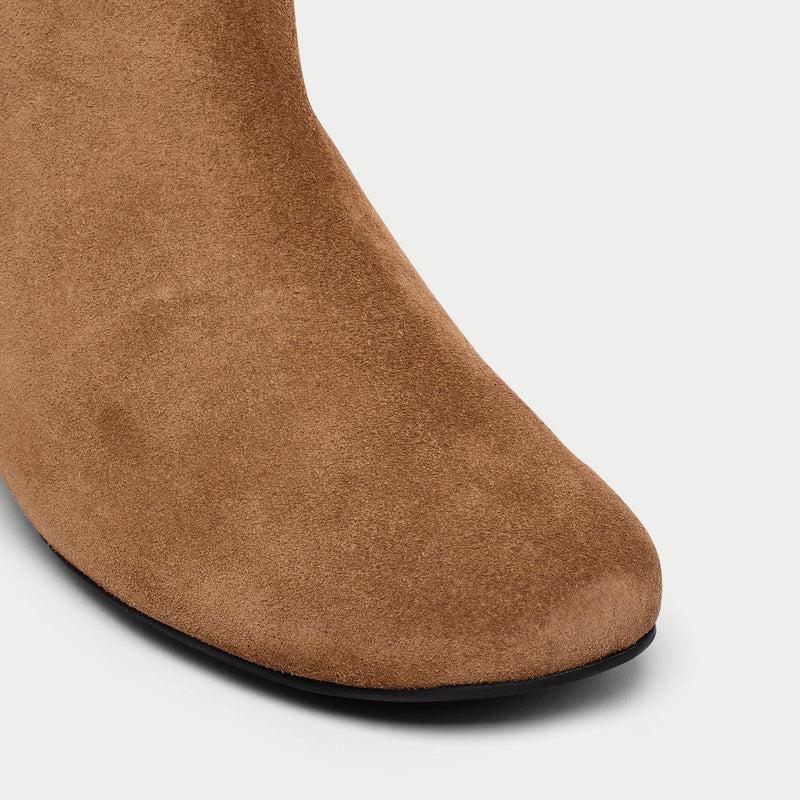 Brown suede boot on a light gray background