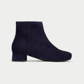 Navy blue ankle boot on a light gray background