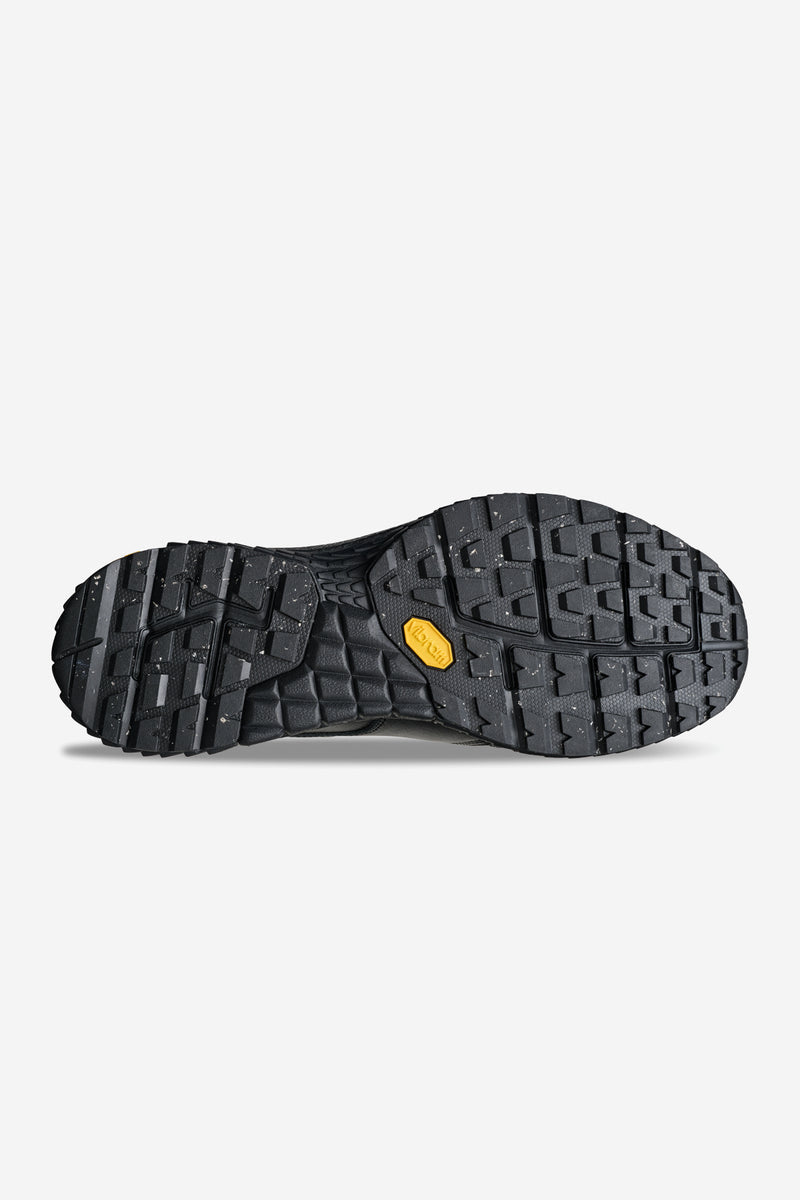 Bottom view of black Liaizon Vibram loafer showing rugged tread outsole with yellow Vibram logo