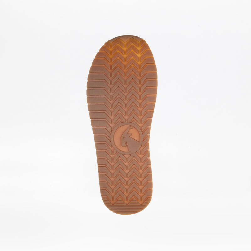 Close-up of a brown rubber sole from the Lilac BILLY Retro Jogger by BILLY Footwear, featuring a herringbone tread and central circular logo, shown against a plain white background.
