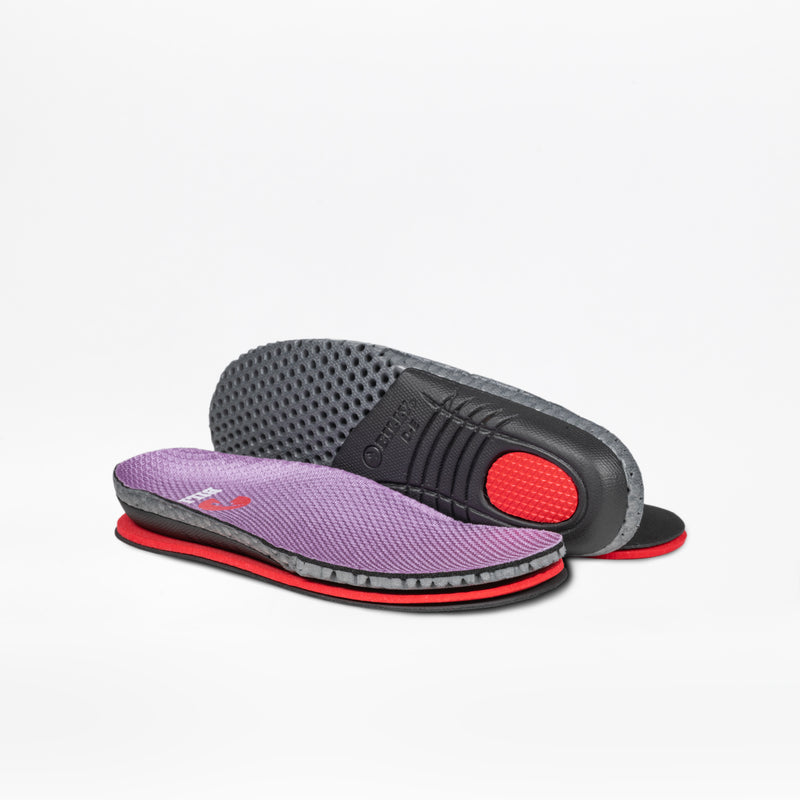 The Lilac Watercolor BILLY Limitless insoles by BILLY Footwear for kids’ orthopedic shoes feature a purple mesh top, red cushioning, and black textured soles. On a white background, one insole shows the top and the other displays the underside.