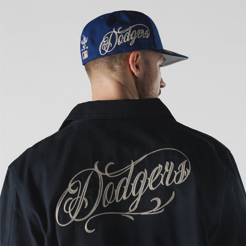 Men's dark navy jacket showing large 'Dodgers' script wordmark on back
