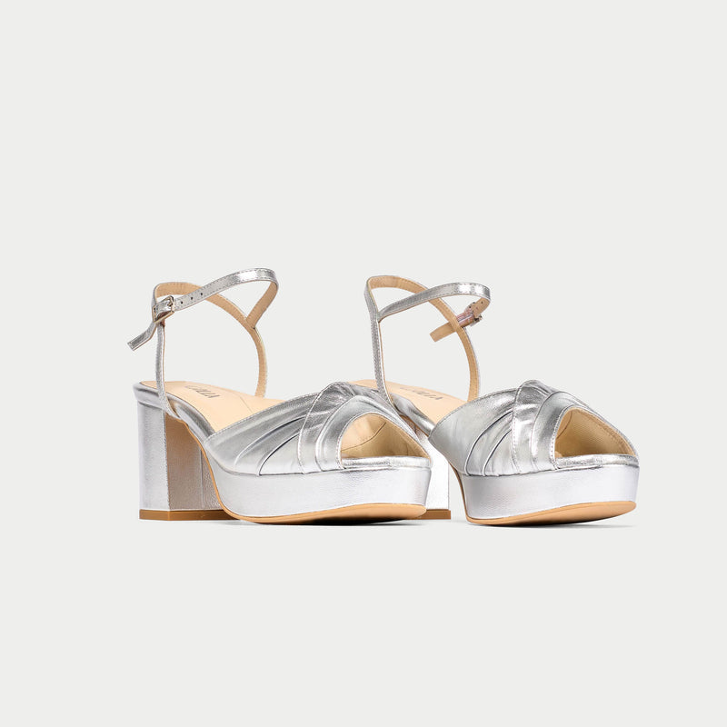 Silver high-heeled sandals on a white background