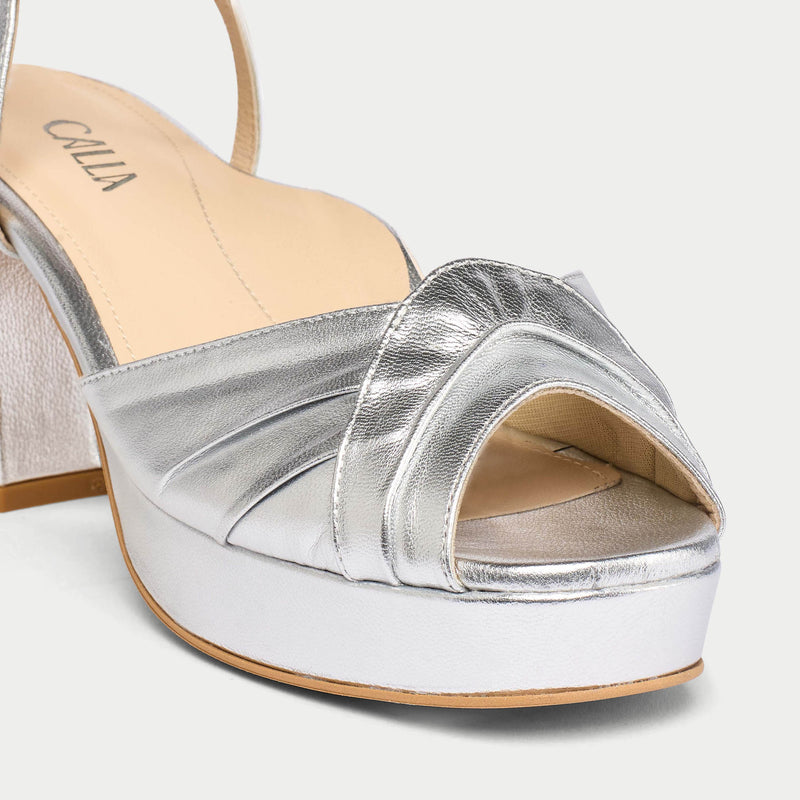 Silver open-toe sandal with a white sole on a light gray background