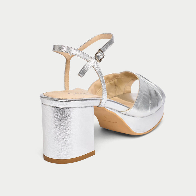 Silver wedge sandal with a beige sole on a white background