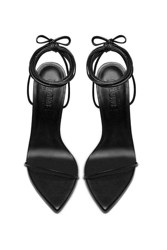 FEMME LA Luce Minimale black sandals — overhead view of the pair showing pointed toes, thin toe straps, and multi-wrap ankle laces tied in bows