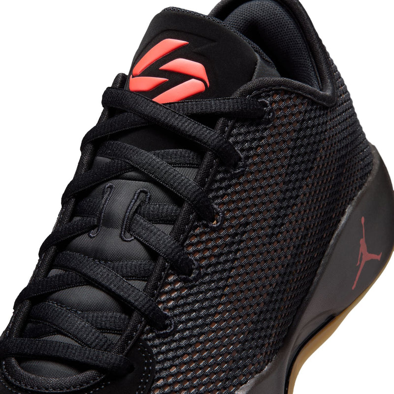 Close-up of men's black lace-up basketball shoe with red curved logo on the side