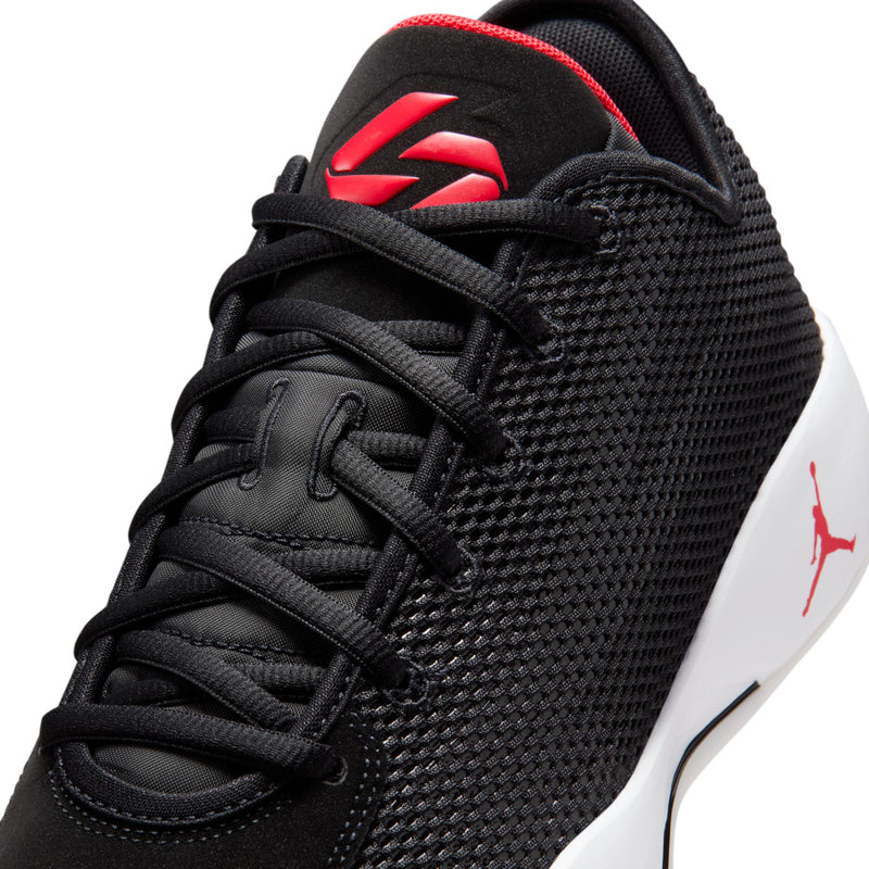 Men's black basketball shoe close-up with red logo on tongue and laces.