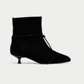 Black ankle boot with a kitten heel on a light gray background