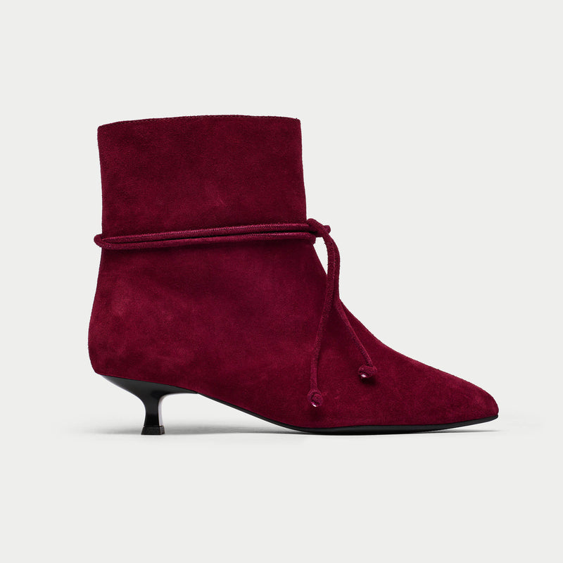 Maroon ankle boot with a pointed toe and kitten heel on a light gray background