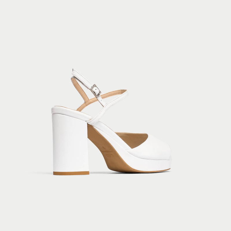 White sandal with a block heel on a light gray background