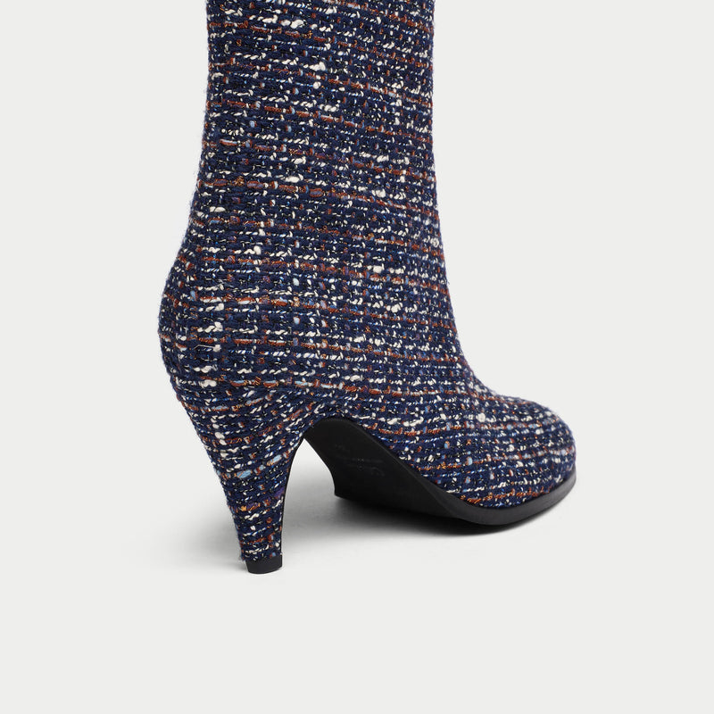 Navy blue tweed Maya ankle boot with a pattern of small white and brown dots on a light gray background heel close-up