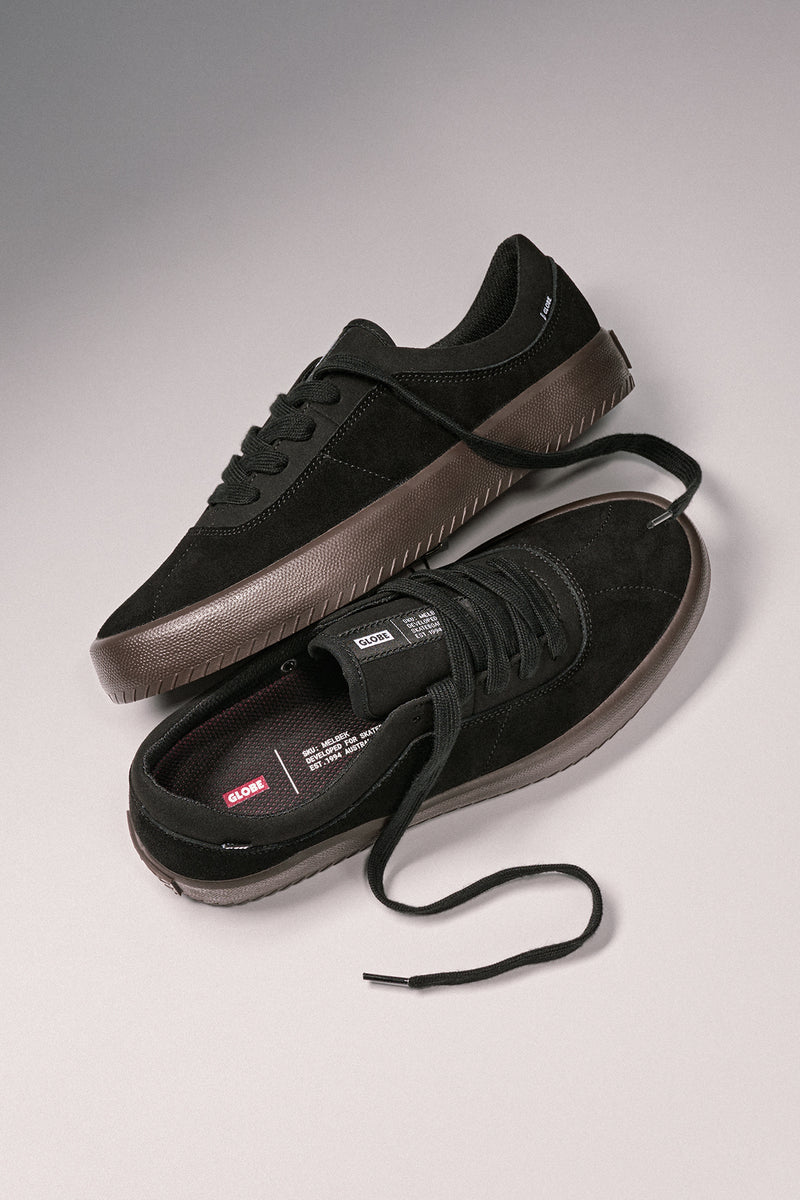 Two black Melbek suede skate shoes shown from above with brown midsoles and laces.