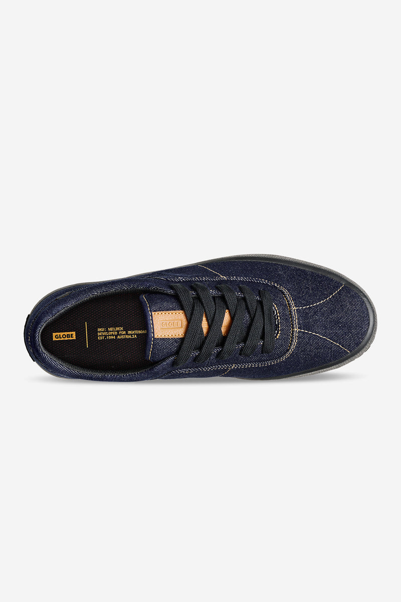 Top view of Melbek Denim skate shoe with dark denim upper, black laces, and tan leather tongue patch