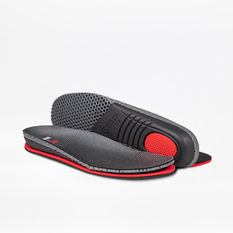 A pair of gray and black insoles with red accents, featuring textured surfaces and raised heel cushions, designed for the Men's Charcoal Suede BILLY Comfort Plush by BILLY Footwear, displayed against a plain white background.