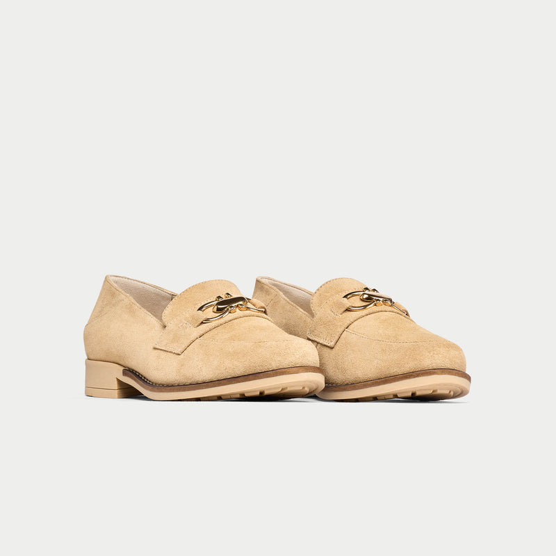 Pair of beige loafers on a light gray background