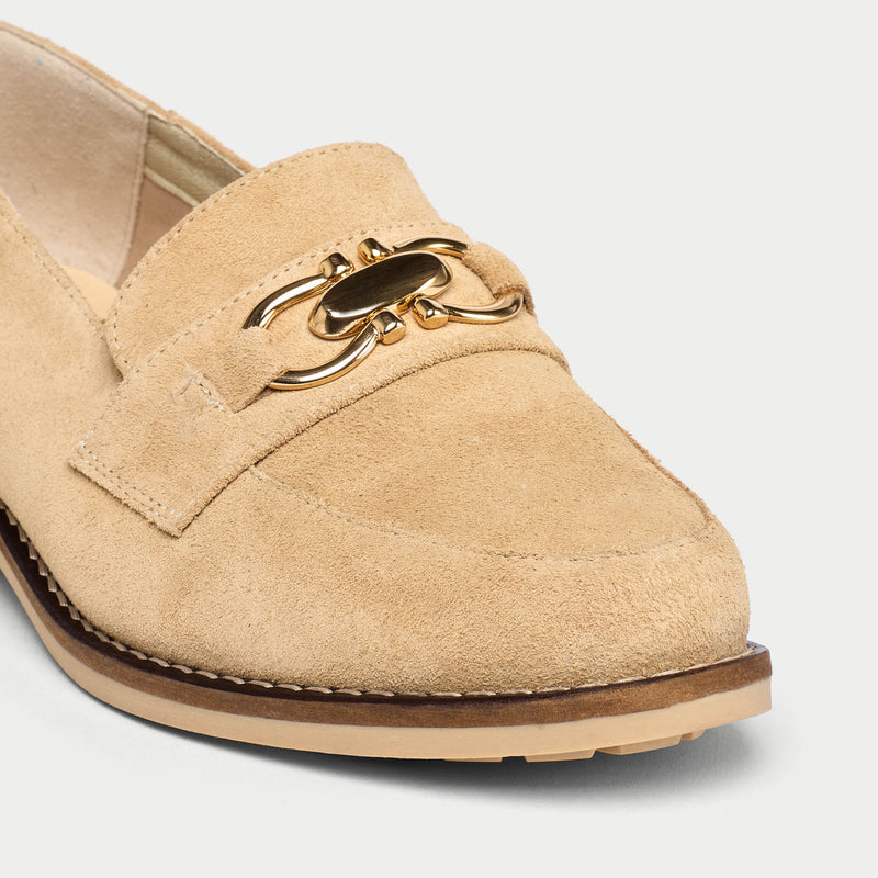 Beige loafer with gold chain detail on a light gray background