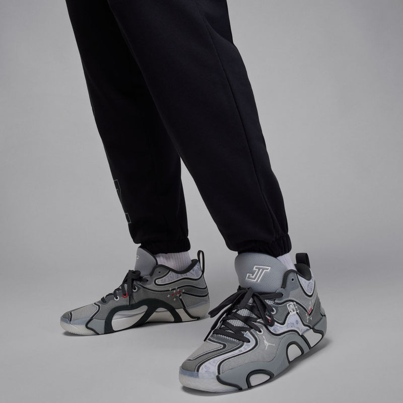 Black tapered jogger pants with elastic cuffs and vertical wordmark print