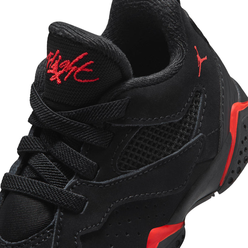 Close-up of kids black sneaker with red logo on tongue and mesh quarter panel