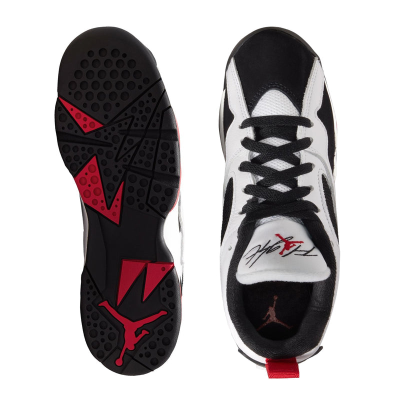 Youth sneaker soles with black traction pods and red geometric pattern accents