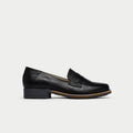 Black loafer shoe on a light gray background