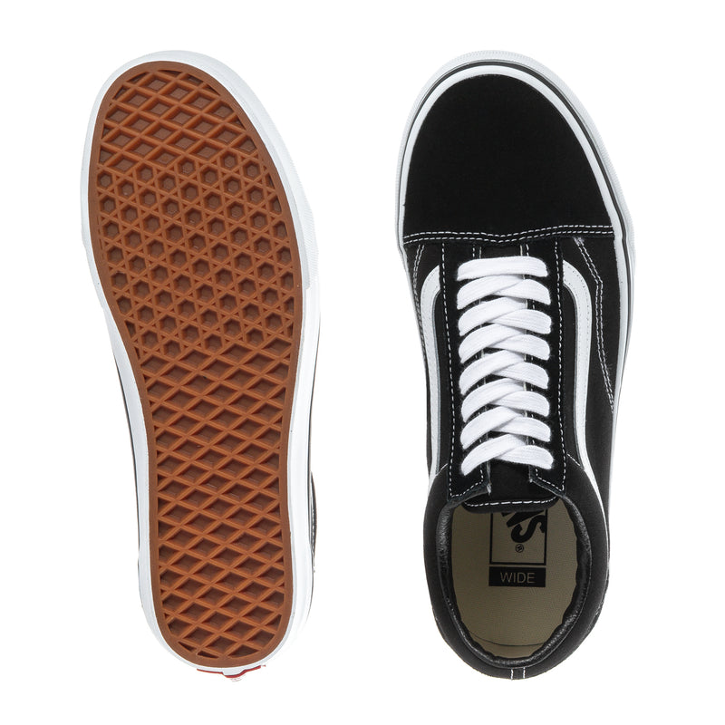 Black sneaker showing white laces, inner label, and tan treaded outsole
