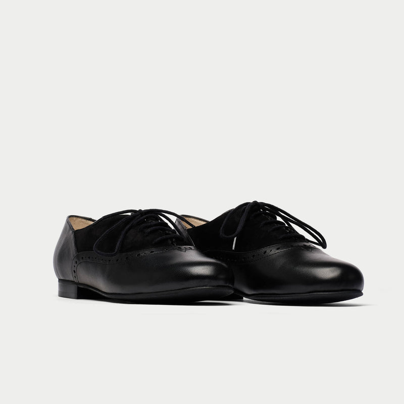 Pair of black leather shoes on a light gray background