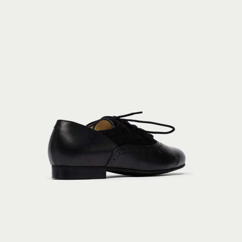 Black leather shoes on a light gray background