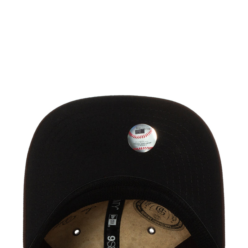 Black baseball cap with embroidered button logo detail on the crown