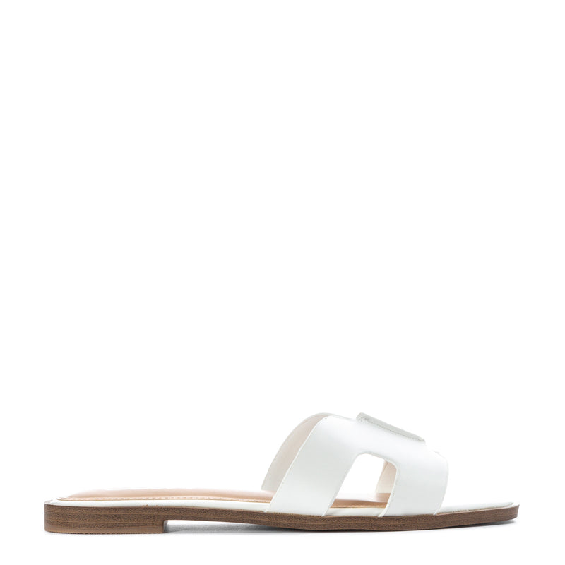 White women's slide sandal with H-band strap and flat brown outsole