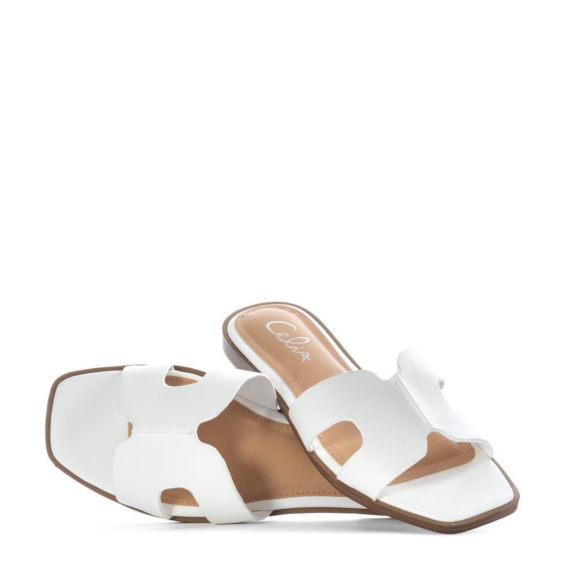 White slide sandal with H-cutout strap and tan insole, 'Celix' logo
