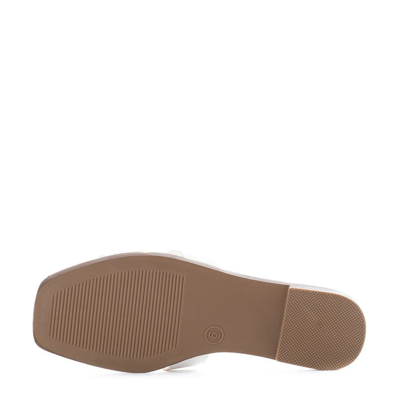 Bottom view of white women's slide sandal with textured rubber sole