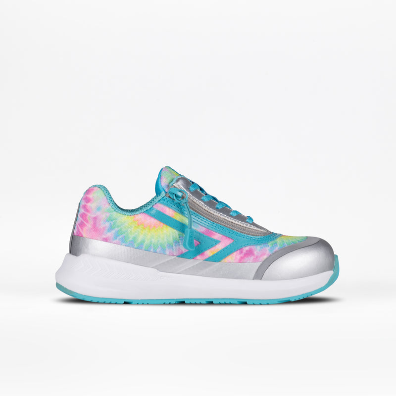 The Rainbow Tie Dye BILLY Goat by BILLY Footwear is a kids' adaptive athletic shoe featuring a vibrant tie-dye pattern in pink, yellow, blue, and green with silver metallic accents and a light blue sole, shown in side profile on white.