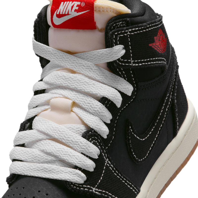 Kids black high-top sneaker close-up of laces, tongue label, and stitched swoosh