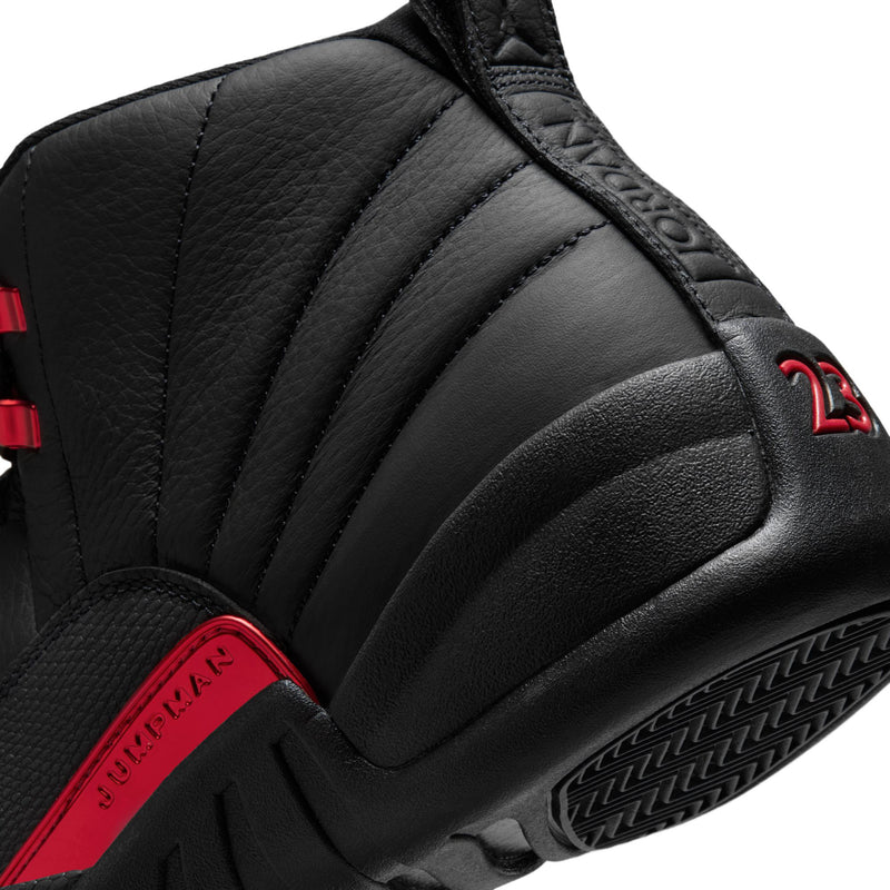 Men's black high-top sneaker close-up with quilted panel, red trim, and outsole