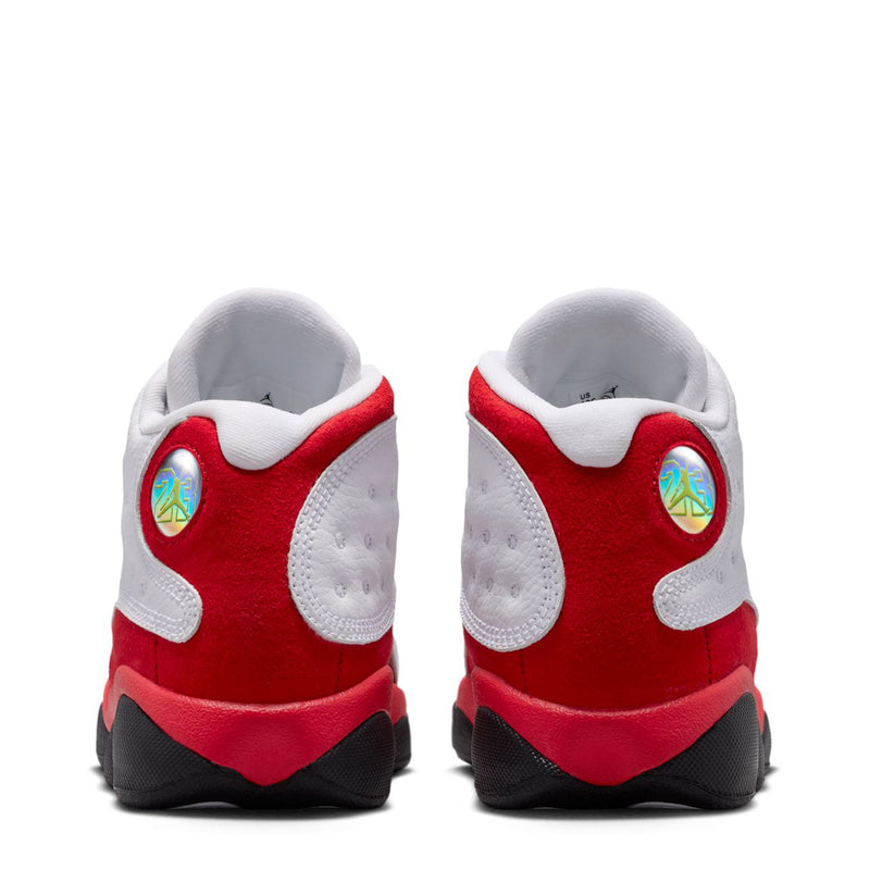 Kids' retro 13 sneakers, white backs with red heel panels and black tread.