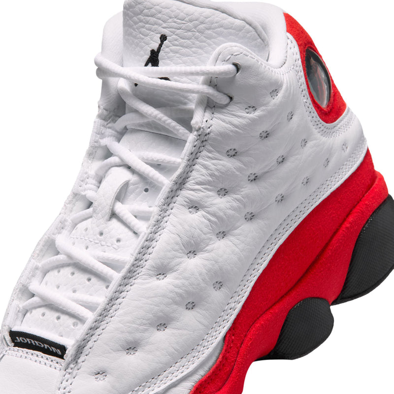 Youth high-top sneaker close-up: white laces, stitched eyelets, red side panel, black sole