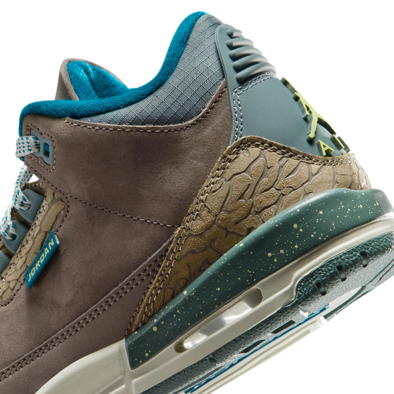 Youth Jordan sneaker close-up, side panel with teal collar and textured tan mudguard