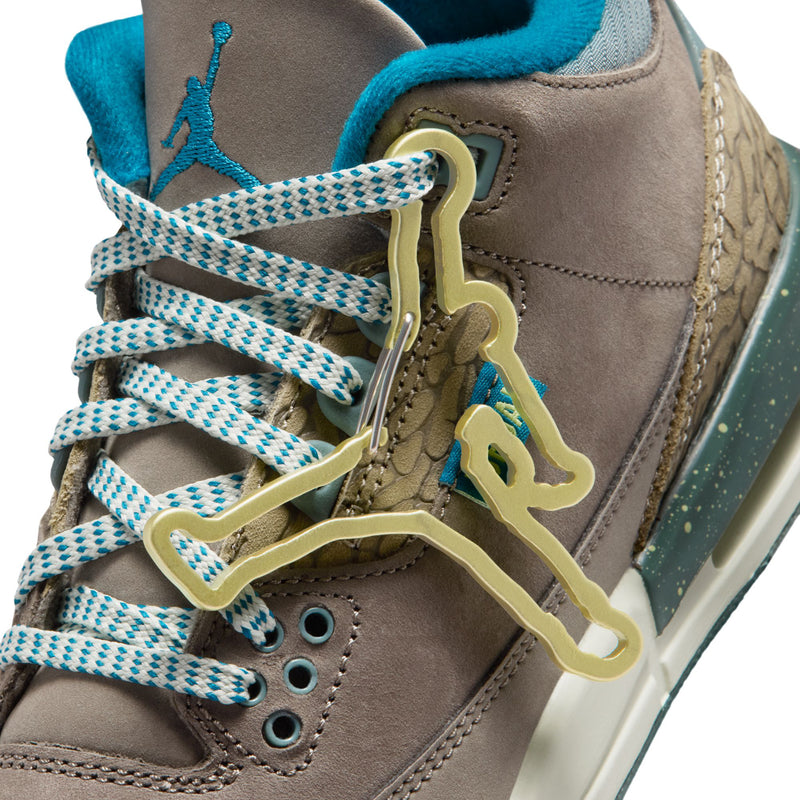 Youth Jordan sneaker close-up, gold lace eyelets, teal laces, and Jumpman tongue tag