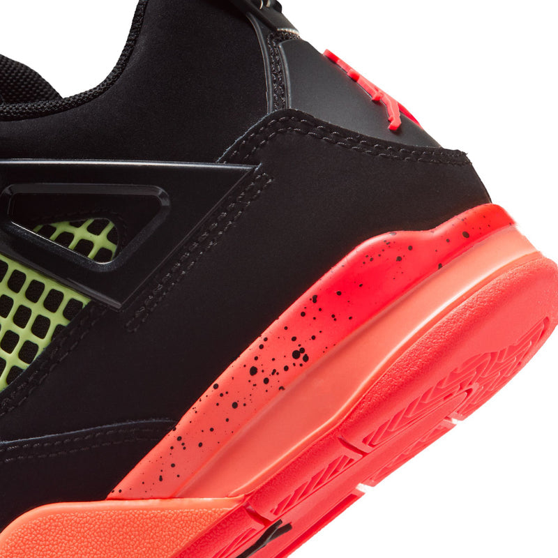 Close-up of kids retro 4 side: black upper with red-orange midsole and speckled accents