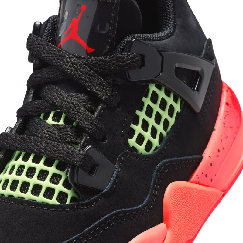 Toddler black sneaker close-up: neon green grid, black laces, red heel logo