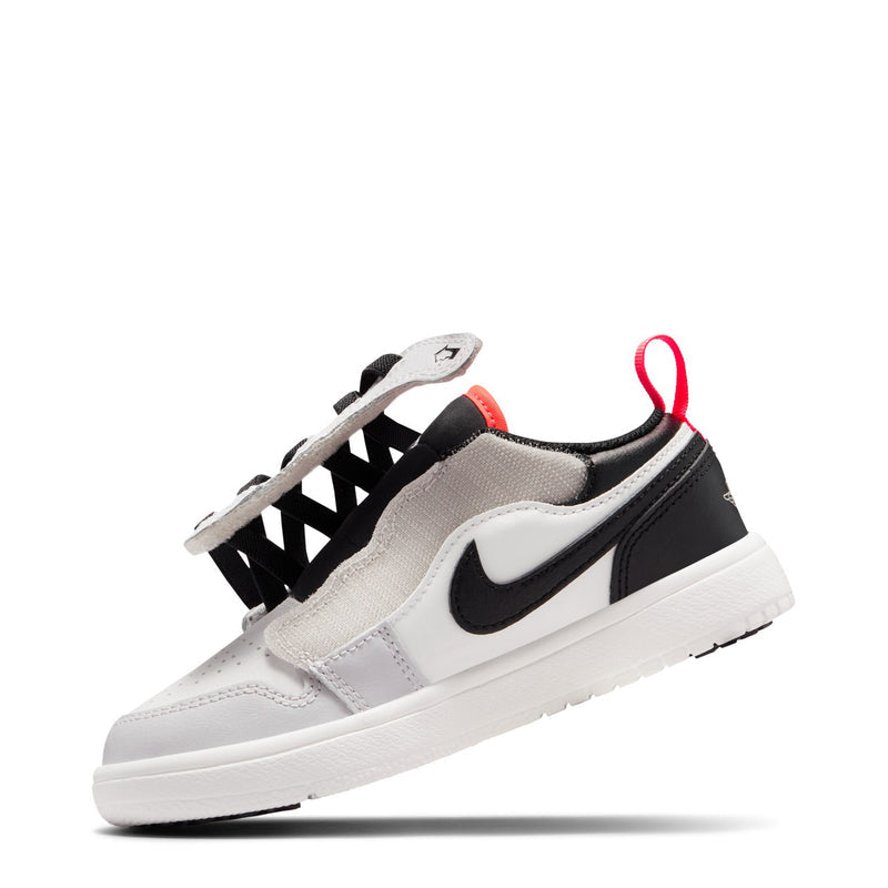 Kids sneaker side view with black swoosh, black straps, red lace tips, sail upper