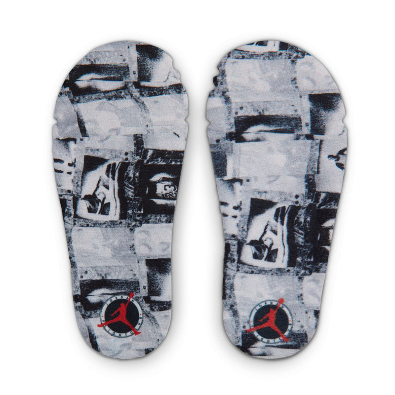 Shoe bottom outsoles with blue-gray graphic print and red Jumpman logo