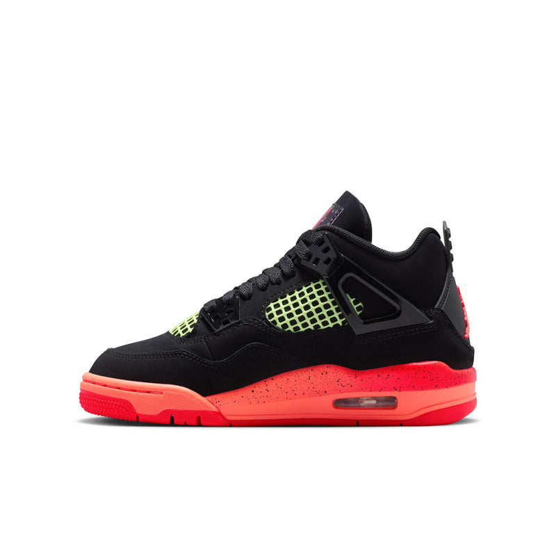 Youth black basketball sneaker side view with neon green grid and red outsole