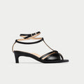 Black sandal with thin straps on a light gray background