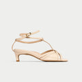 Beige sandal with thin straps on a light beige background