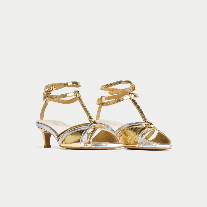 Gold kitten-heeled shoes with clear straps on a white background