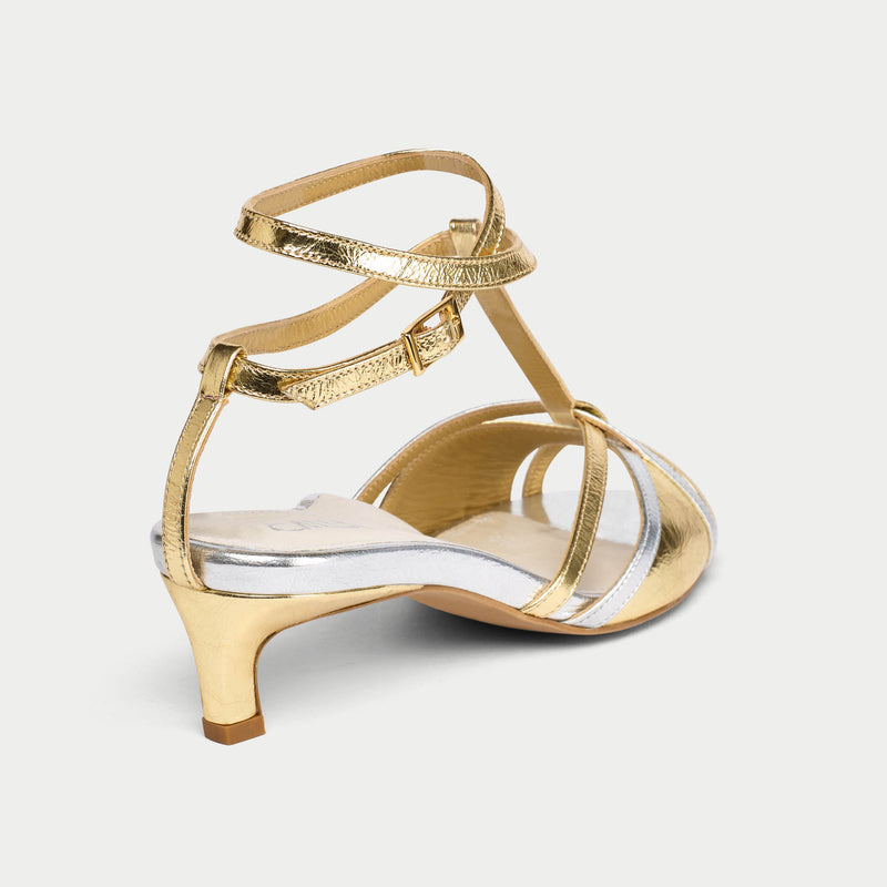 Gold kitten-heeled sandal on a light gray background