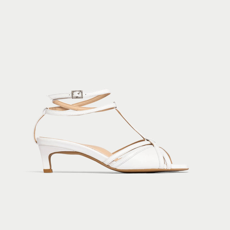 White kitten-heeled shoe with clear mesh panels on a white background